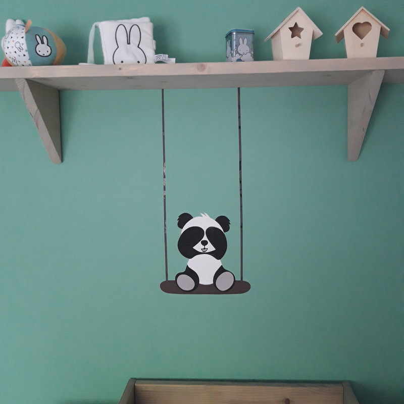 Muursticker behang pandabeer op schommel boven commode.