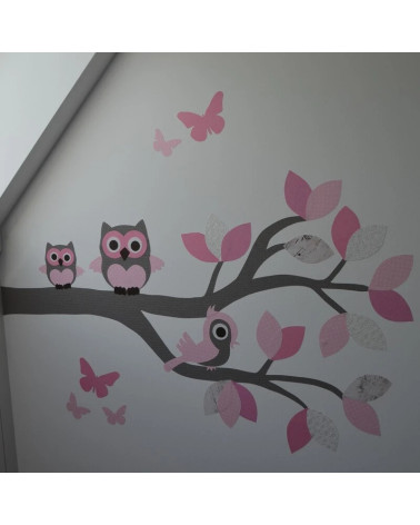 Muursticker behang tak met roze uilen en een vogel.