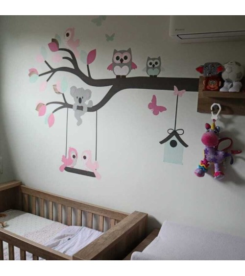 Behang sticker baby meisjeskamer roze en groene tak met uiltjes en vogel.