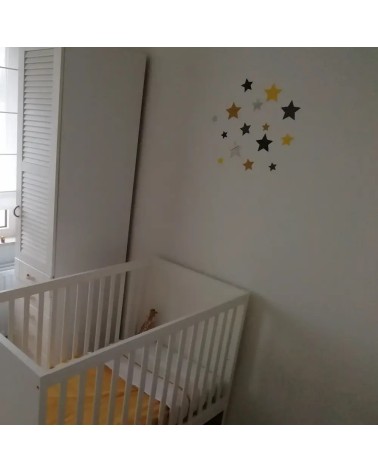 Behangsticker set sterren boven het ledikantje in de babykamer.