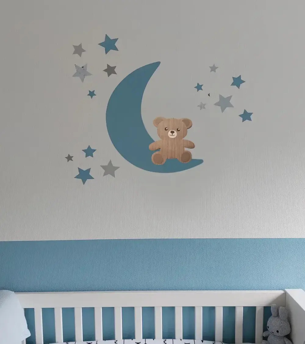Behangsticker jongens babykamer zittend teddybeertje op een lichtblauwe maan met sterren.
