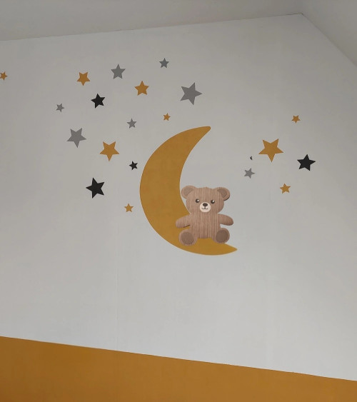 Behangsticker jongens babykamer zittend teddybeertje op een lichtblauwe maan met sterren.