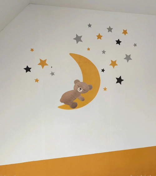 Behangsticker babykamer donkergroene maan en sterren met een slapend teddybeertje.