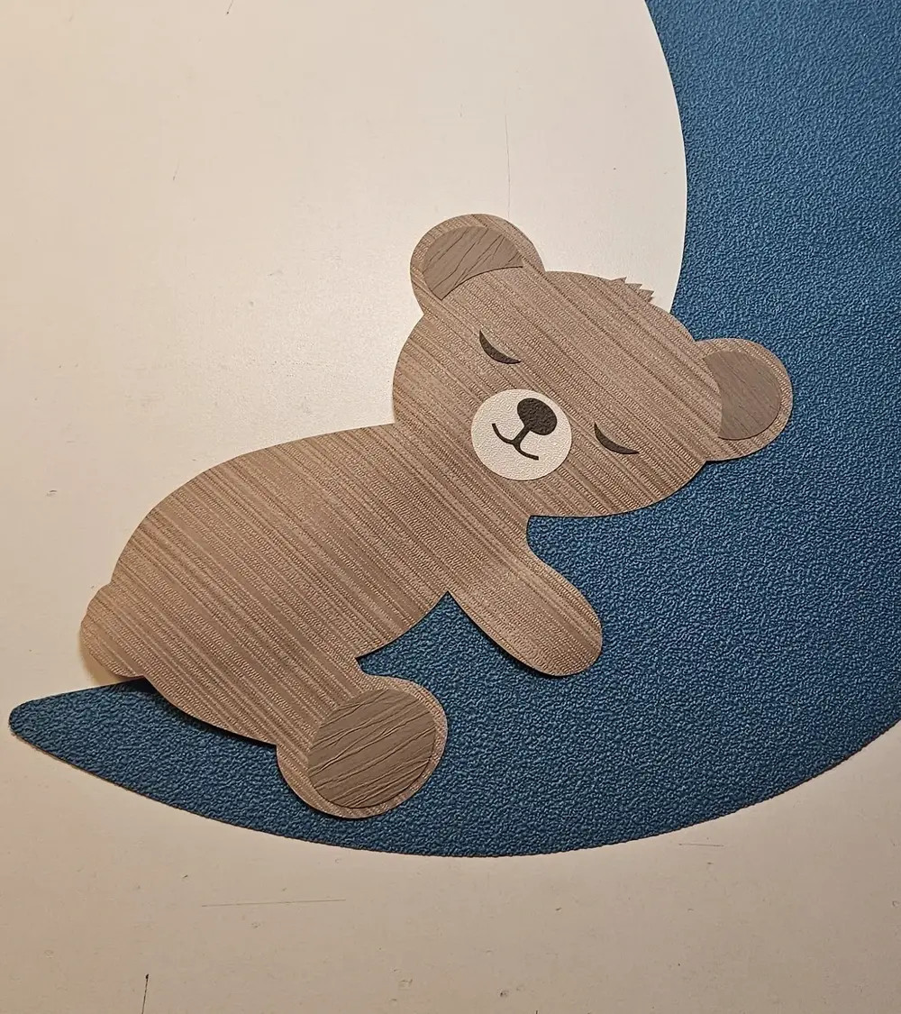 Behangsticker slapend teddybeertje rechtskijkend op een maan muurdecoratie babykamer.