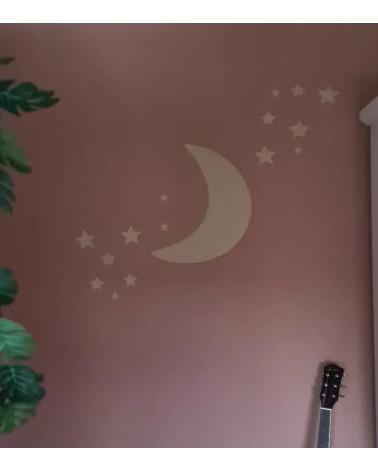Behangsticker meisjeskamer gouden maan met sterren op een roze muur.