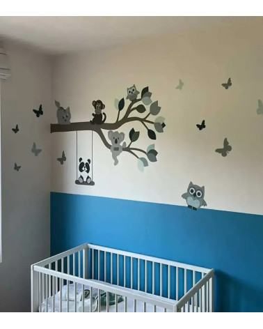 Behangsticker spelende poes op tak met dieren in een blauwe babykamer.