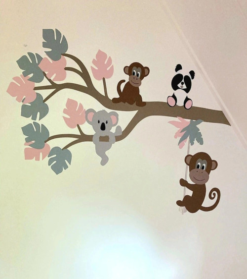 Sierlijke jungle tak meisjeskamer met slingeraap in oud roze en oud groen.