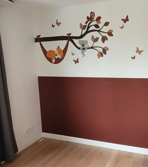 Muursticker babykamer tak met vosje in hangmat in natuurlijke groentinten.