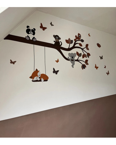 Behangsticker babykamer met een tak met vrolijke dieren in de kleuren roest en terracotta met een vosje op de schommel.
