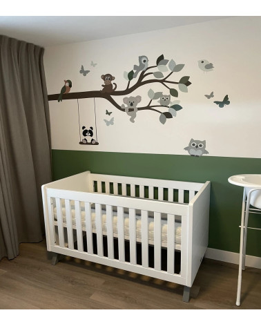 Behangsticker tak met vrolijke dieren in een groene babykamer.