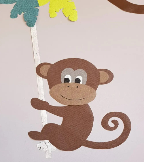 Behangsticker jungle kamer grote aap aan touw boven de commode.