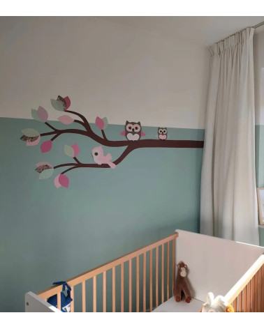 Behang sticker baby meisjeskamer roze en groene tak met uiltjes en vogel.