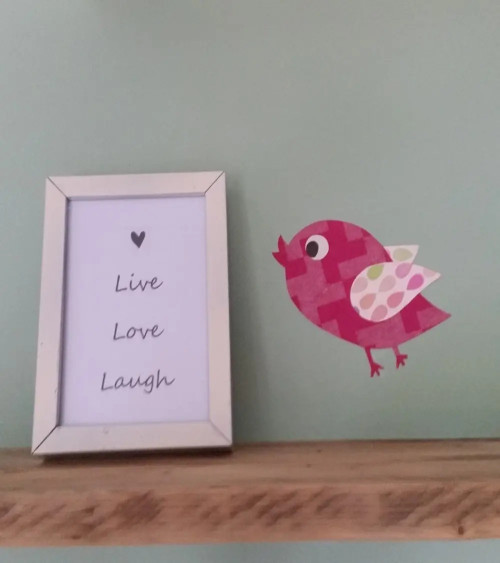 Behang muursticker vliegend vogeltje fel roze.