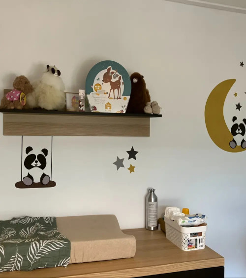 Behangsticker pandabeertje op schommel boven commode.