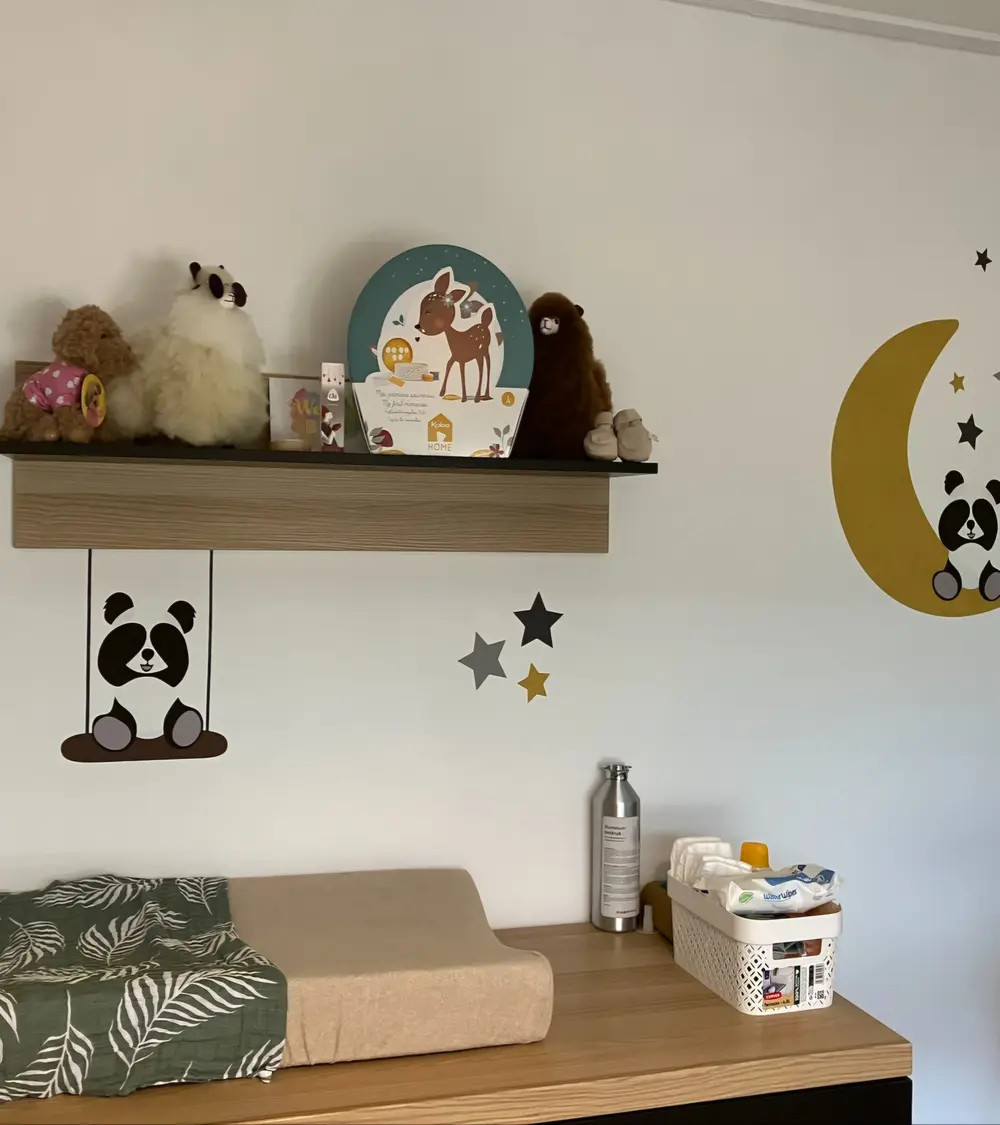 Behangsticker pandabeertje op schommel boven commode.