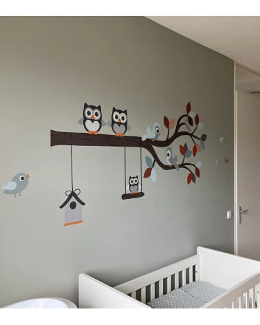Behangsticker kinderkamer sierlijke uilentak in de kleuren oud groen, roest en rood.