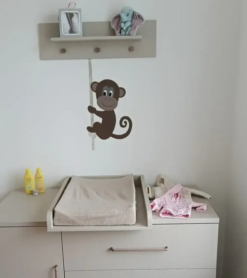 Behangsticker jungle kamer grote aap aan touw boven de commode.