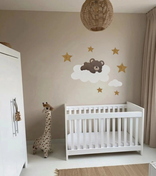 Behangsticker babykamer slapend teddybeertje op een wolk met gouden sterren.