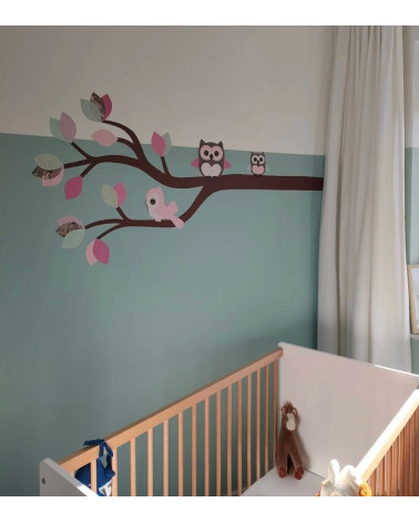 Behangsticker meisjeskamer met een sierlijke uilentak in zacht roze en mintgroen.