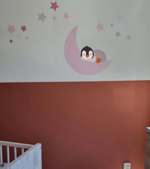 Behangsticker pinguïn op een maan met sterren in zachte roze tinten.