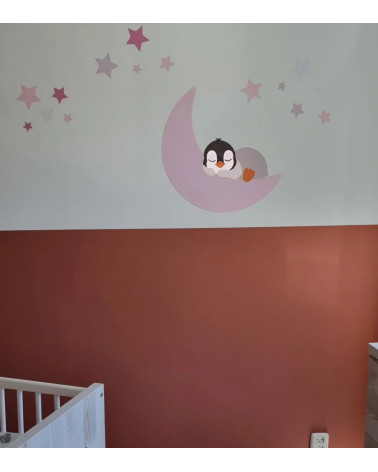 Behangsticker pinguïn op een maan met sterren in zachte roze tinten.