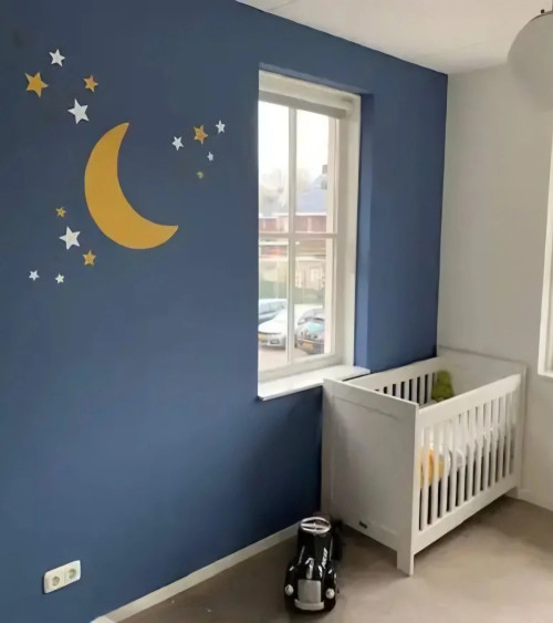 Behangsticker maan met sterren okergeel in een stoere blauwe jongenskamer.