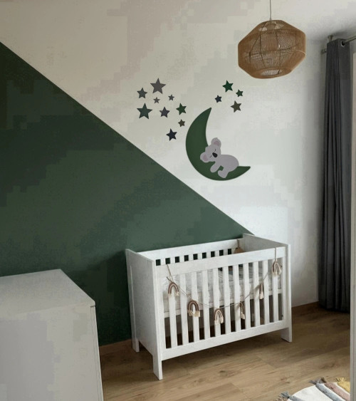 Een behangsticker voor de kinderkamer met een slapend koalabeertje op een donkergroene maan.