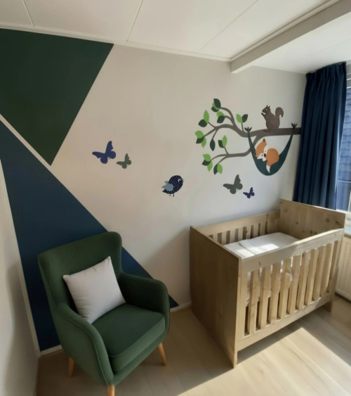 Muursticker babykamer tak met bosdieren en vosje in hangmat in donkergroen en donkerblauw.