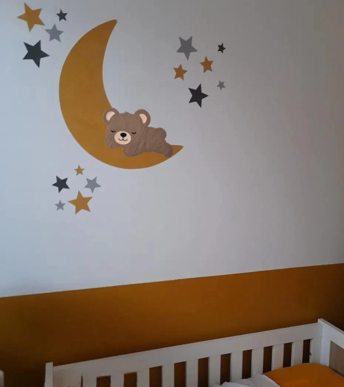 Muurdecoratie kinderkamer met een okergele maan en een slapend teddybeertje.