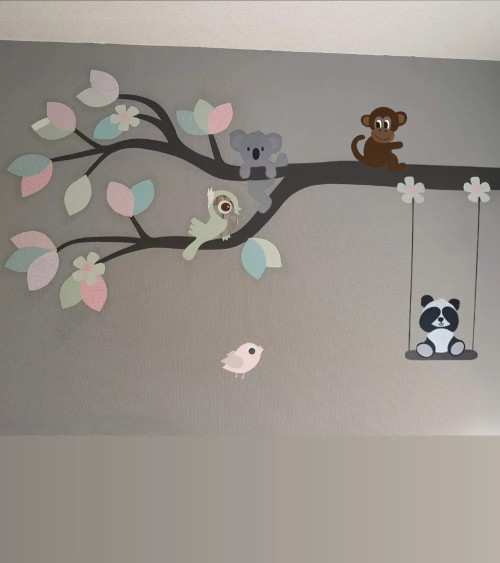 Behang muurdecoratie meisjeskamer van een tak met dieren in roze, mintgroen en lichtblauw.