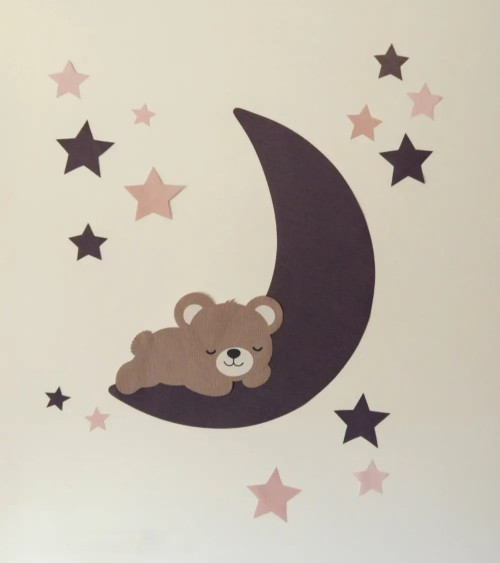 Een behangdecoratie voor de kinderkamer van een slapende teddybeer op een maan en sterren in paars en roze.