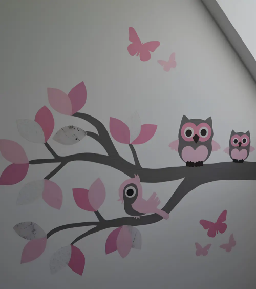 Muursticker behang tak met roze uilen en een schommel met vogels.