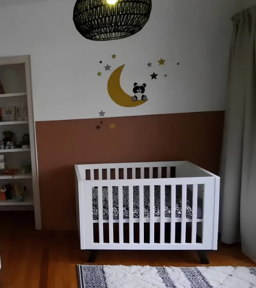 Panda beer op maan muurdecoratie in een terracotta babykamer.