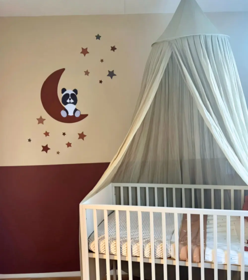 Terracotta babykamer met een pandabeer op de maan muurdecoratie.