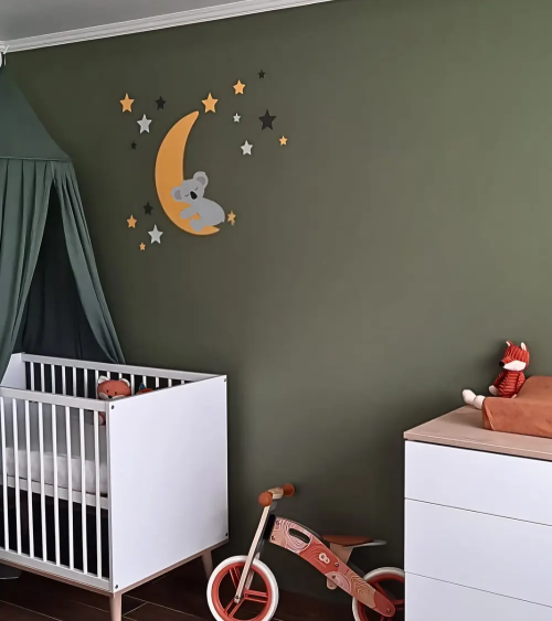 Slapende koalabeer op een okergele maan behangsticker in een donkergroene babykamer.