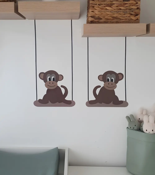 Behangsticker baby aapjes op schommel boven de commode.