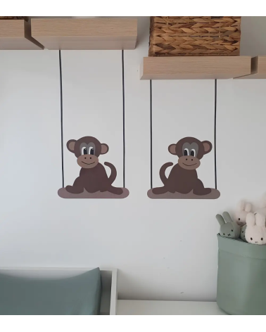 Behangsticker baby aapjes op schommel boven de commode.