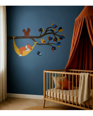 Muurdecoratie van een bosdierentak met een vosje in een hangmat in een donkerblauwe en terracotta babykamer.