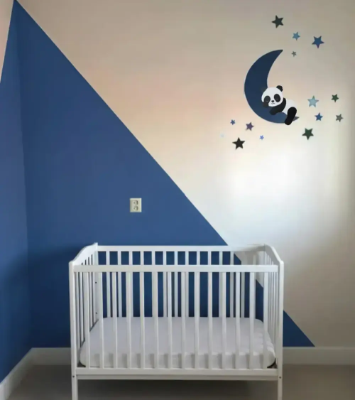 Blauwe jongens babykamer met een slapende pandabeer op een maan behangsticker.