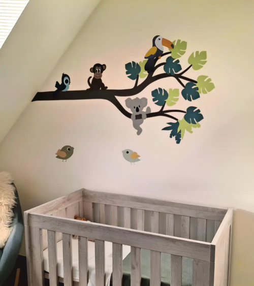 Behangsticker jungle tak met vrolijke jungle dieren in beige babykamer.