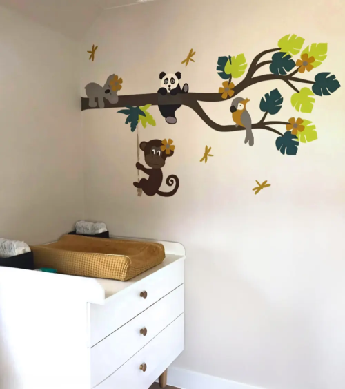 Behang muursticker jungle kamer met okergele accenten en een jungle tak met dieren .