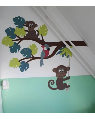 Muursticker babykamer Jungle tak met jungledieren en groene jungle bladeren.