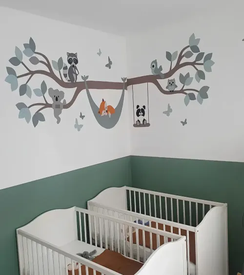Behangsticker bosdieren boom tak in een groene tweeling babykamer.