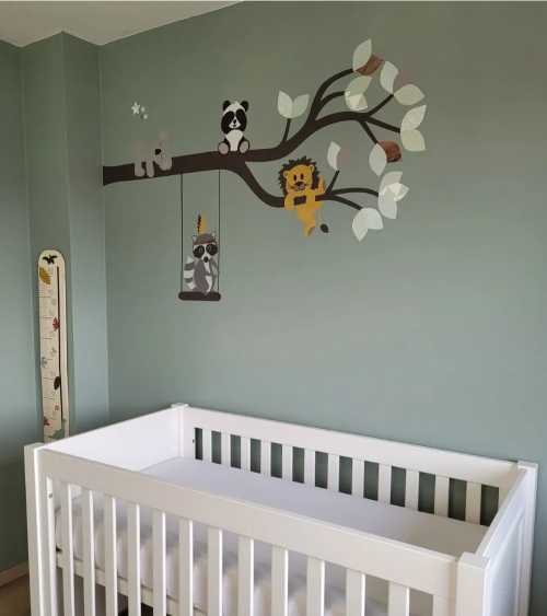 Saliegroene babykamer met en schattige dieren tak als muurdecoratie.