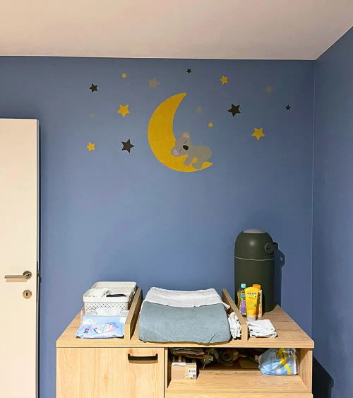 Behangsticker slapende koalabeer op een okergele maan in een blauwe babykamer.