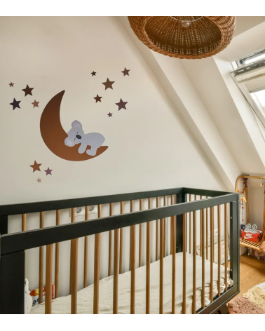 Een behangsticker viir de babykamer met een slapend koalabeertje op een roestbruine maan met sterren.
