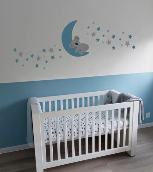 Behangsticker babykamer slapende koalabeer op de maan met sterren lichtblauw.
