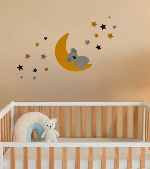 Behangsticker babykamer slapende koalabeer op de maan met sterren okergeel.