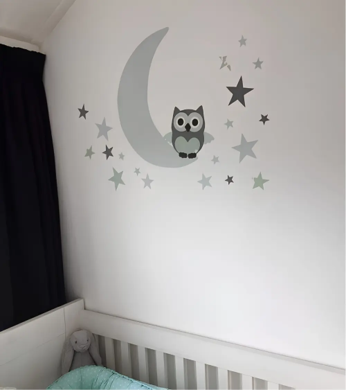 Babykamer behangdecoratie met een uiltje op een mintgroene maan en sterren.