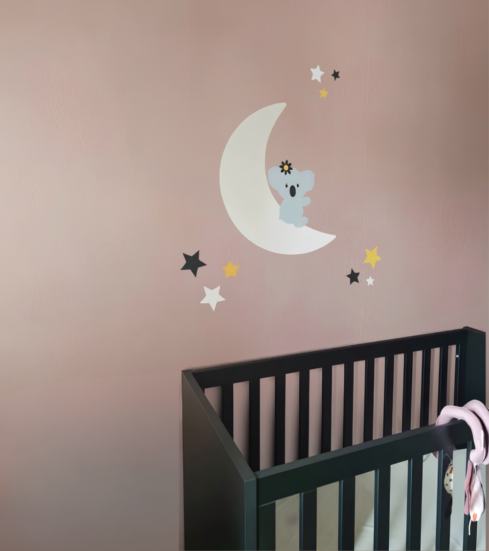 Behang muursticker roze babykamer zittende koalabeer op een witte maan met sterren in wit, zwart en oker.